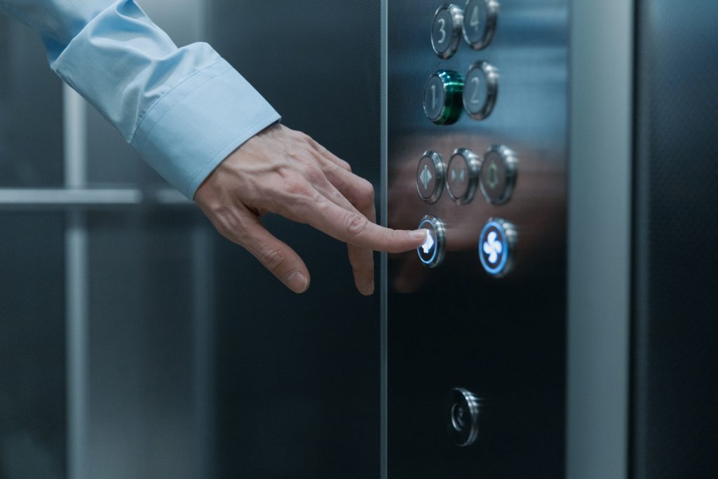 Main sur bouton d'ascenseur